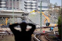 Ein Beobachter verfolgt in Berlin den Abriss der Ringbahn-Brücke. - © Christoph Soeder/dpa