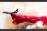 Ein Flugzeug wirft Löschmittel über dem Mandeville Canyon in Los Angeles ab. - © Brian Cahn/ZUMA Press Wire/dpa