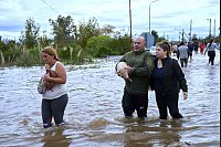 Bewohner waten durch überflutete Straßen nach heftigen Regenfällen in Campana, Argentinien. - © Rodrigo Abd/AP/dpa