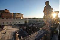 Papst Franziskus gestorben: Die Sonne geht hinter einer Statue auf dem Petersplatz, vor der Beerdigung von Papst Franziskus im Vatikan, auf. - © Markus Schreiber/AP/dpa