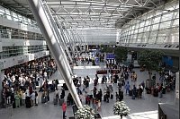 Reisende stehen im Flughafen Düsseldorf in langen Warteschlangen an der Gepäckabgabe. (Archivbild) - © David Young/dpa