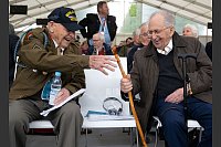 Bud Gahs (l), Veteran der US-Truppen, und Abba Naor, Überlebender des KZ Dachau, sitzen zusammen am 80. Jahrestag der Befreiung des Konzentrationslagers Dachau. - © Sven Hoppe/dpa