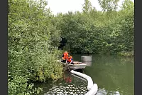 Mitarbeiter des Abwasserwerks legen sogenannte Ölschlängel und Ölbindemittel auf der Wasseroberfläche aus. - © Freiwillige Feuerwehr Leopoldshöhe