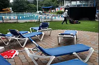 Keiner da, den es stört: Schwimmmeisterin Sonja Jakobskrüger mäht kurz vor dem Regen in Berlebeck-Heiligenkirchen noch den Rasen. - © Foto: Preuss