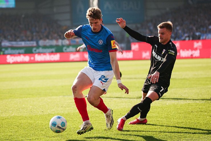 Kiels Lasse Rosenboom (l) und Stuttgarts Maximilian Mittelstädt im Kampf um den Ball. - © Christian Charisius/dpa