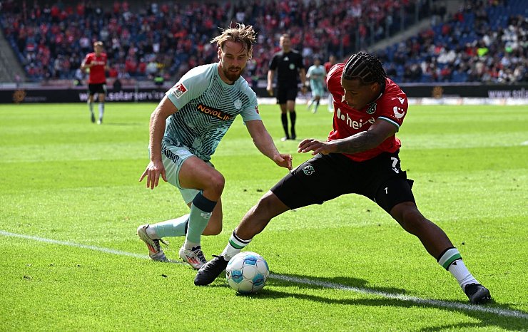 Hannovers Jessic Ngankam (r) schirmt den Ball vor Kaiserslauterns Jannis Heuer ab. - © Carmen Jaspersen/dpa