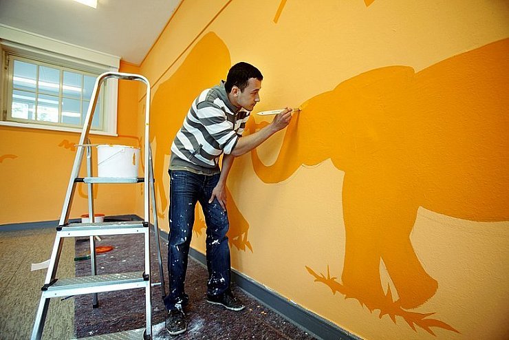 Arbeit an der Schule: Design-Student Alexander Schmitke malt in der ehemaligen Südholzschule eine Elefantenfamilie an die Wand. - © Foto: Preuss