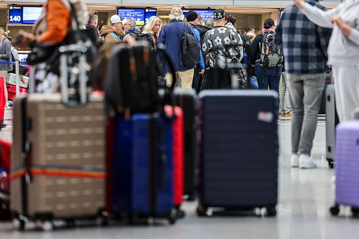 Reisende stehen am Flughafen der Landeshauptstadt. (Archivbild) - © Christoph Reichwein/dpa