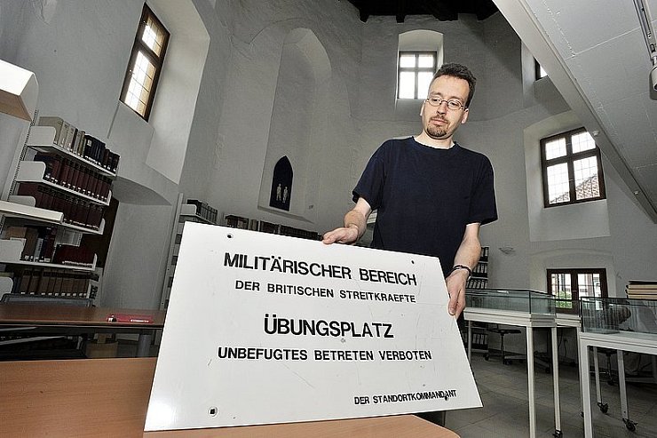 Leiter Marcel Oeben zeigt ein eingelagertes Schild, das bis Mitte der 1990er Jahre vor dem Betreten des damaligen Truppenübungsplatzes Biesterberg warnte. - © Foto: Krull