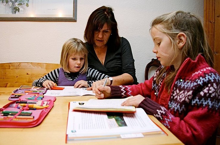 Martina Kelm hilft Linea (7, links) und Lydia (8) bei den Hausaufgaben.