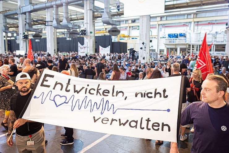 Auf der Betriebsversammlung in Wolfsburg begrüßen Mitarbeiter den Vorstand mit scharfem Protest gegen die jüngsten Sparpläne. - © Moritz Frankenberg/dpa Pool/dpa