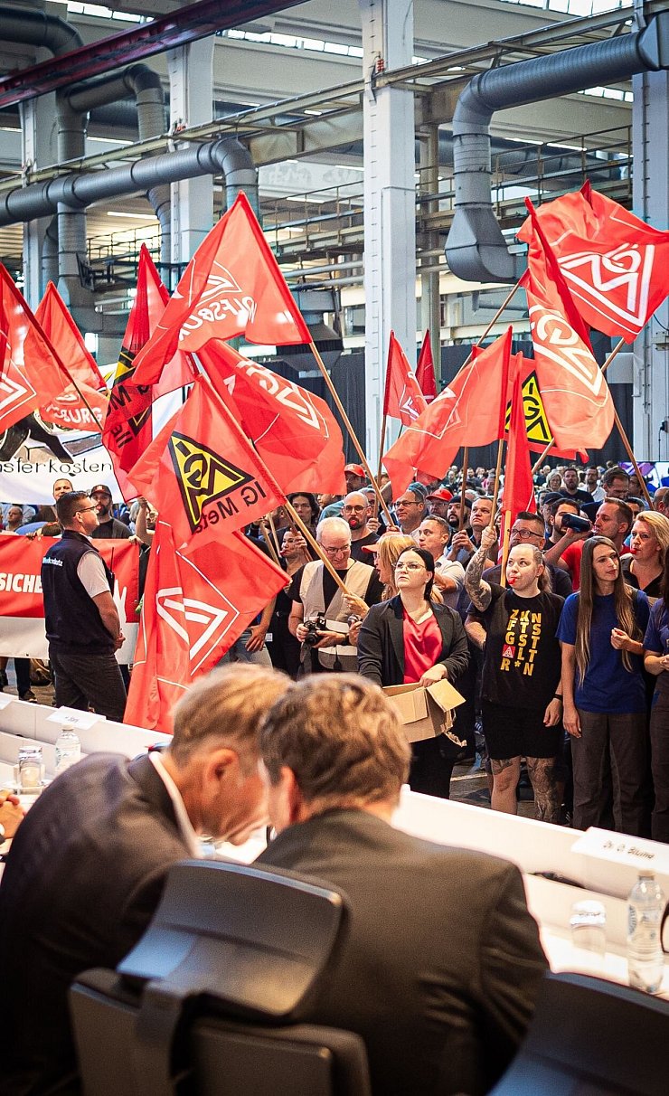 Auf der Betriebsversammlung in Wolfsburg begrüßen Mitarbeiter den Vorstand mit scharfem Protest gegen die jüngsten Sparpläne. - © Moritz Frankenberg/dpa Pool/dpa