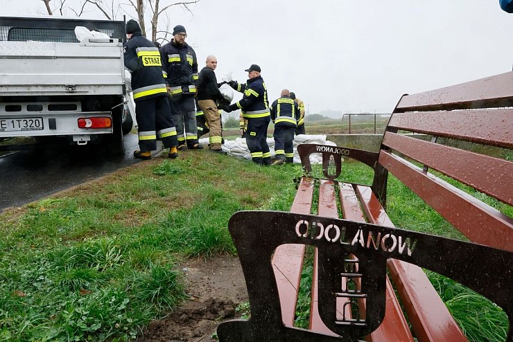 Feuerwehrleute in Polen errichten mit Sandsäcken eine Barriere gegen das drohende Hochwasser in der Nähe des Flusses Barycz in Odolanow. - © Tomasz Wojtasik/PAP/dpa