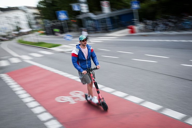Ein Mann fährt auf einem Radweg in Hamburg mit einem E-Scooter. - © Christian Charisius/dpa