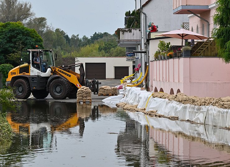 Ein Sandsack-Wall wird in einem Stadtteil von Eisenhüttenstadt verstärkt. Dort hat das Hochwasser Straßen überflutet. - © Patrick Pleul/dpa