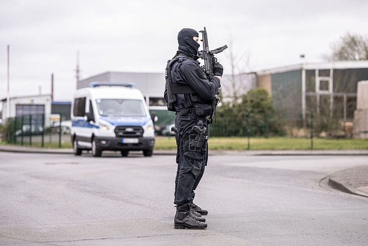 Ein vermummter Polizeibeamter bei der Razzia in Burgsteinfurt gegen mutmaßliche Autoschieber. - © Guido Kirchner/dpa