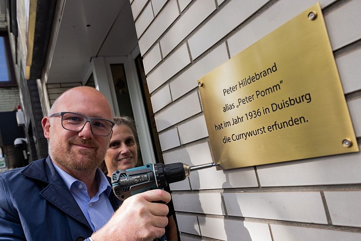 Mit der neuen Plakette macht Oberbürgermeister Sören Link (SPD) klar: Hier in Duisburg wurde die Currywurst erfunden. - © Rolf Vennenbernd/dpa
