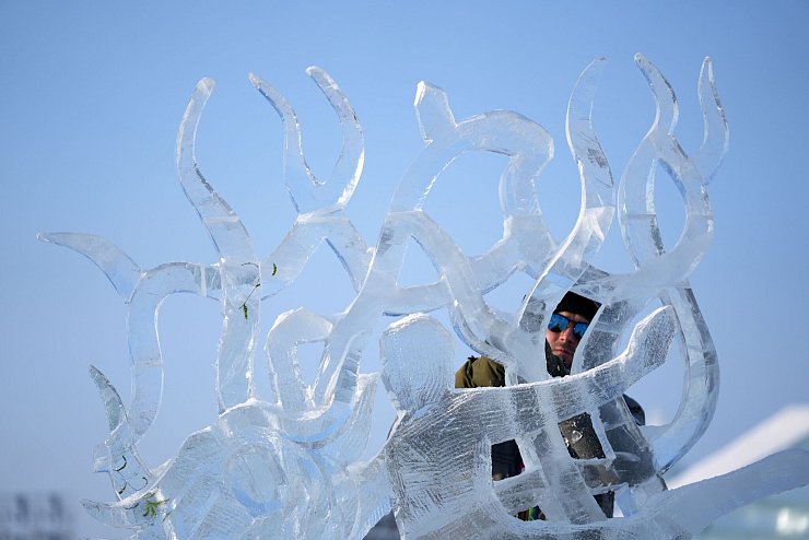 Ein Teilnehmer des Wettbewerbs arbeitet an einer Eisskulptur beim Internationalen Eisskulpturenwettbewerb. - © Wang Jianwei/XinHua/dpa