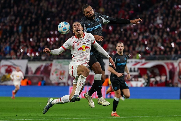 Leipzigs Yussuf Poulsen (l.) im Zweikampf mit Jonathan Tah. - © Jan Woitas/dpa