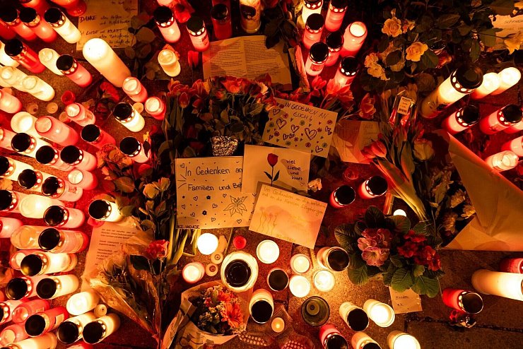 Kerzen und Blumen in der Nähe des Tatorts. - © Pia Bayer/dpa