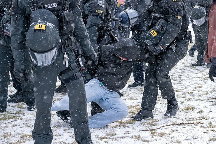 Polizisten bringen am Rande einer Demonstration eine Person zu Boden. - © Pia Bayer/dpa