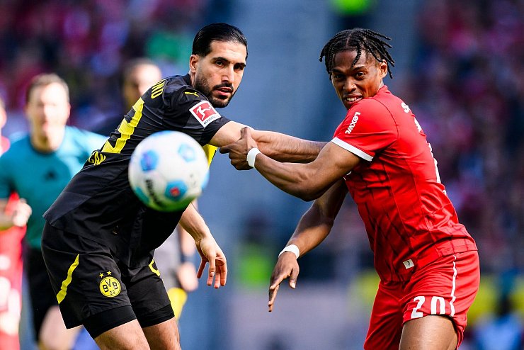 Den Ball im Blick: Dortmunds Emre Can und Junior Adamu vom SC Freiburg. - © Tom Weller/dpa