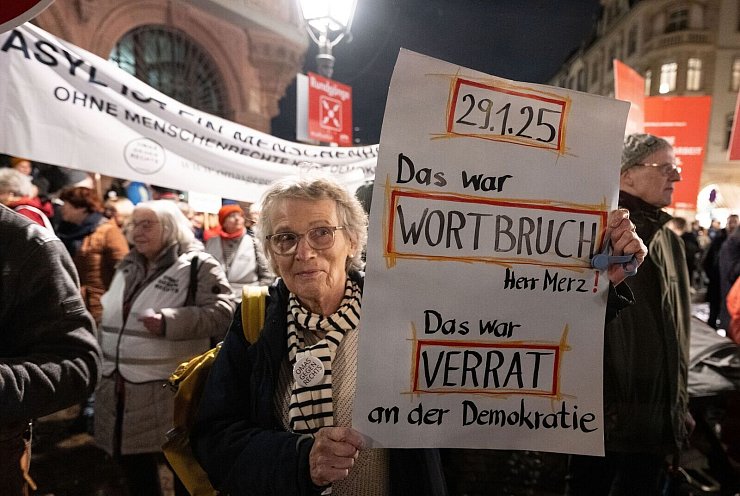 Demonstranten protestieren auf dem Römerberg in Frankfurt am Main gegen die aktuellen Entwicklungen in der Migrationspolitik. - © Boris Roessler/dpa
