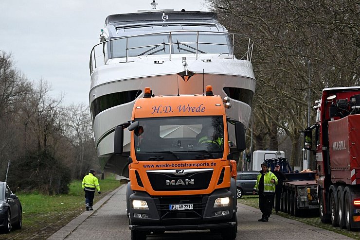 Die aus dem Rhein gehobene Luxusjacht «Princess S65» wird mit einem Tieflader auf das Messegelände gefahren. - © Federico Gambarini/dpa