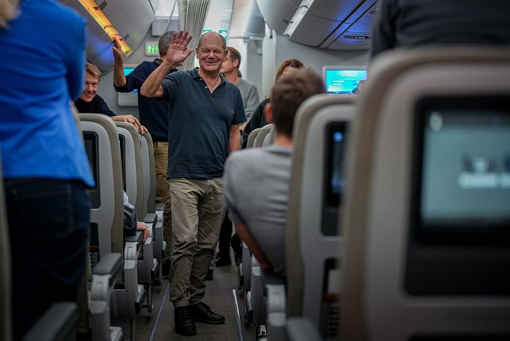 Ein Winken vom Kanzler auf dem Rückflug aus Brasilien. - © Kay Nietfeld/dpa