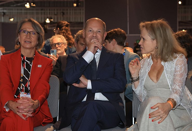 Bundeskanzler Olaf Scholz (SPD, M), sitzt bei der Eröffnung der 25. Welt-Aids-Konferenz zwischen Birgit Poniatowski (l), Geschäftsführerin der International AIDS Society (IAS) und Sharon Lewin (r), Präsidentin der International AIDS Society. - © Karl-Josef Hildenbrand/dpa