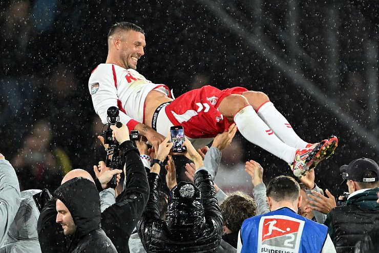 Gefeierte Kultfigur: Lukas Podolski wird von seinen Mitspielern gefeiert. - © Federico Gambarini/dpa