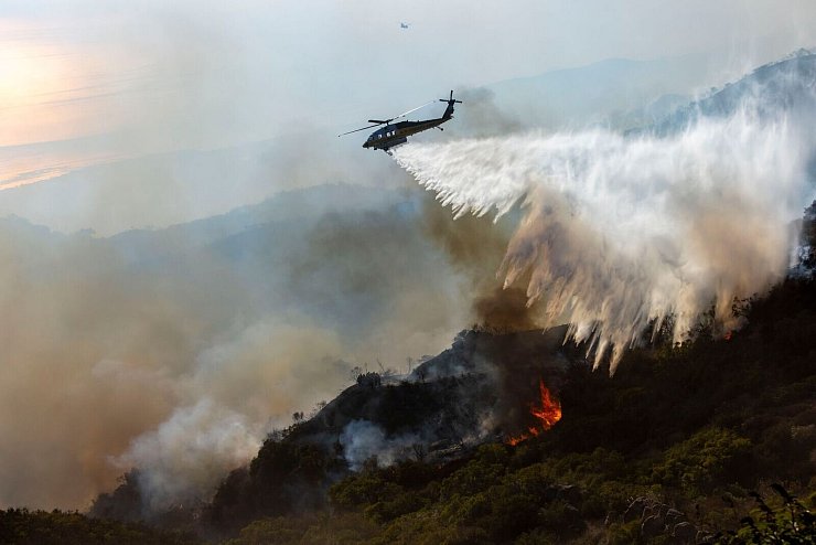 Rund 1.700 Feuerwehrleute bekämpften die Flammen - teils auch aus der Luft. - © Jill Connelly/ZUMA Press Wire/dpa