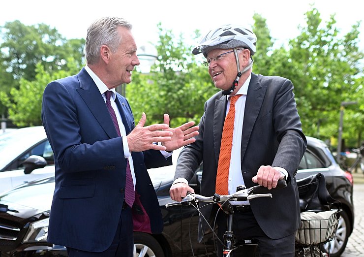 Mit Helm und Fahrrad kommt Stephan Weil (r) zur Wahl, bei der auch Christian Wulff zu Gast ist. - © Julian Stratenschulte/dpa