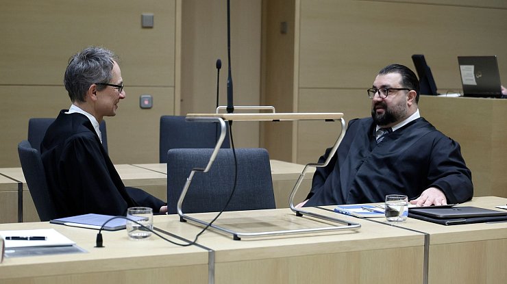 Die Anwälte von E. besprechen sich vor der Verhandlung. - © Ronald Wittek/epa/Pool/dpa