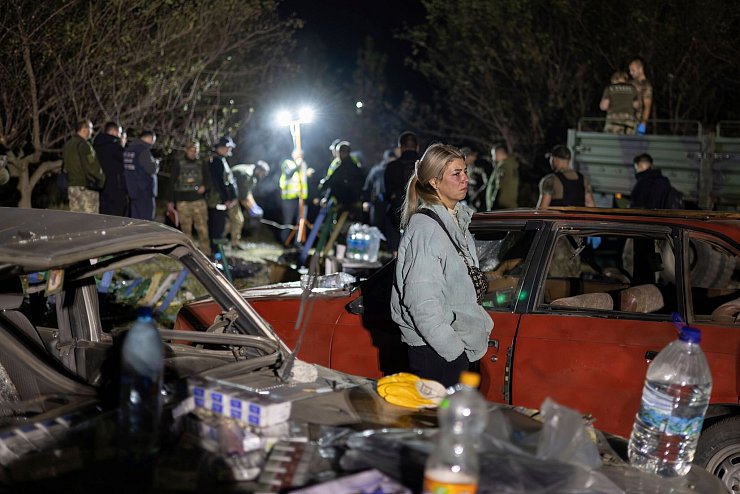 Angehörige der Opfer und Rettungskräfte am Einschlagsort im ukrainischen Dorf Hrosa. - © Alex Babenko/AP