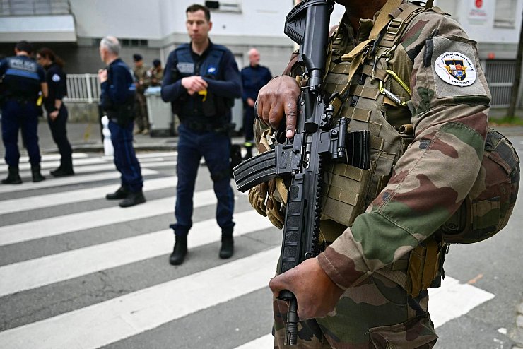 Französische Militärs und Polizisten sind in der Nähe des Gymnasiums im Einsatz. - © Loic Venance/AFP/dpa