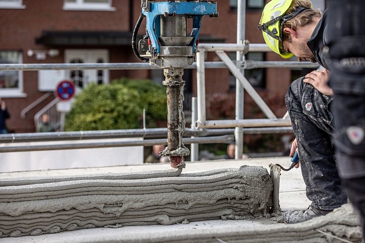 Schicht um Schicht statt Stein auf Stein: Zwei Geschosse und weitere Fertigbausteile entstanden in Lünen per 3D-Druck (Archivfoto) - © Dieter Menne/dpa