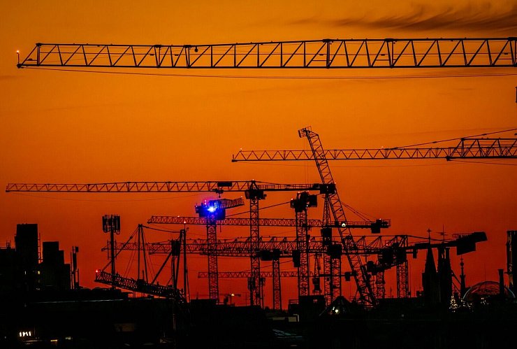 Kran-Ballett: Baukräne, die im Zentrum von München stehen, sind nach Sonnenuntergang vor dem Abendhimmel zu sehen. - © Peter Kneffel/dpa