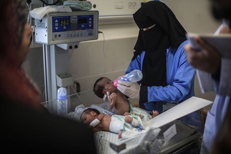 Eine palästinensische Ärztin bereitet ein Frühgeborenes in einem Krankenhaus für die Überführung nach Ägypten vor. - © Mohammed Talatene/dpa