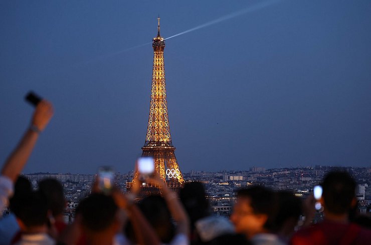 Paris im Sommer 2024 - besonders beliebt: Touristen fotografieren den Eiffelturm mit den Olympischen Ringen von der Terrasse des Triumphbogens. (Archivbild) - © Jan Woitas/dpa
