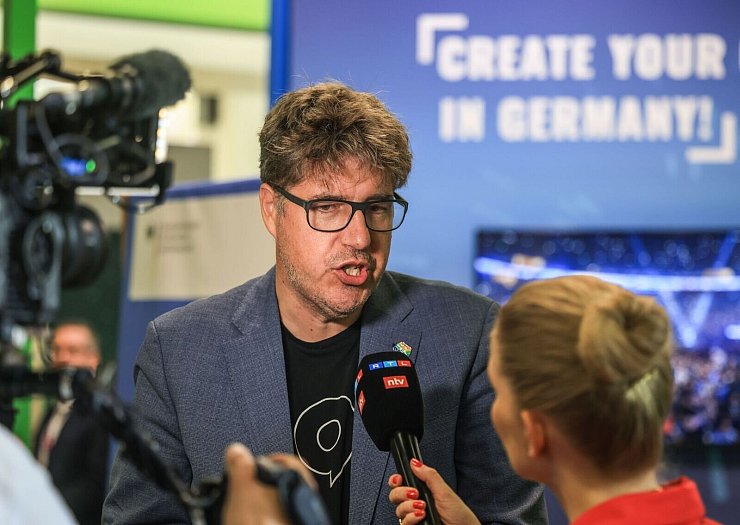 Der Staatssekretär im Bundeswirtschaftsministerium, Michael Kellner (Grüne), spricht mit einer Journalistin. - © Oliver Berg/dpa