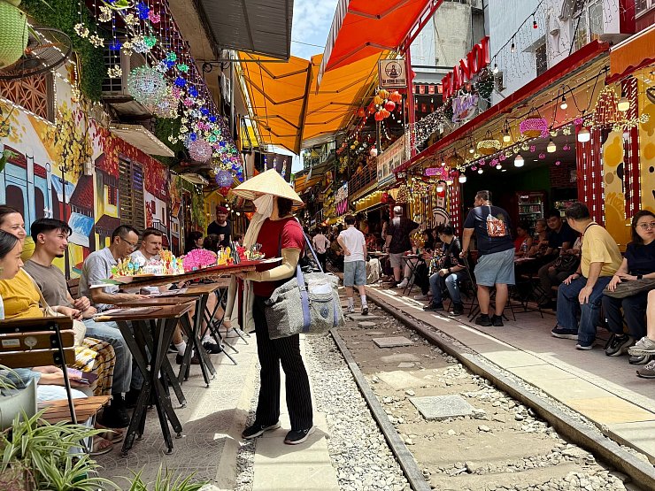 Die Train Street in Hanoi ist eine der bekanntesten Sehenswürdigkeiten. Seit die sozialen Medien 2018 die malerische Zugtrasse für sich entdeckt haben, kommen Touristen aus aller Welt. Besucher sitzen hier in Cafés, während Züge direkt vor ihren Nasen vorbeidonnern. - © Carola Frentzen/dpa