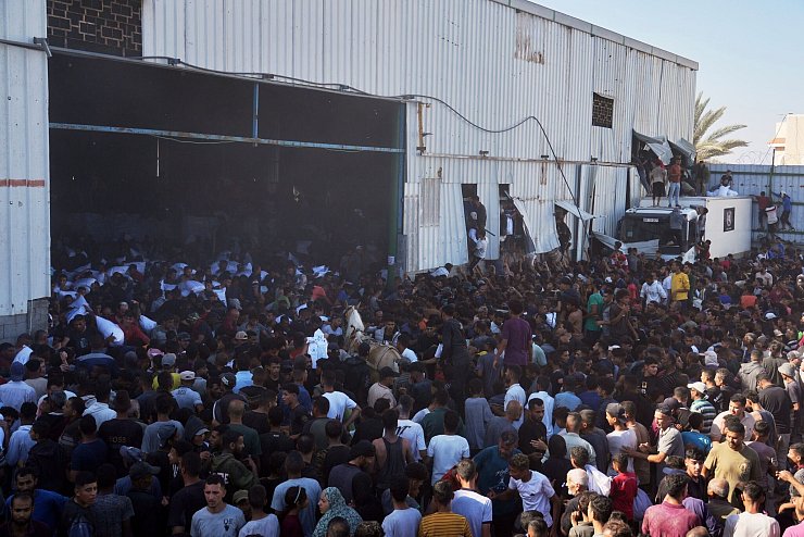Palästinenser tragen Säcke mit Mehl, nachdem sie ein Lagerhaus des Welternährungsprogramms der Vereinten Nationen in Zawaida im zentralen Gazastreifen gestürmt haben. - © Abdel Kareem Hana/AP/dpa