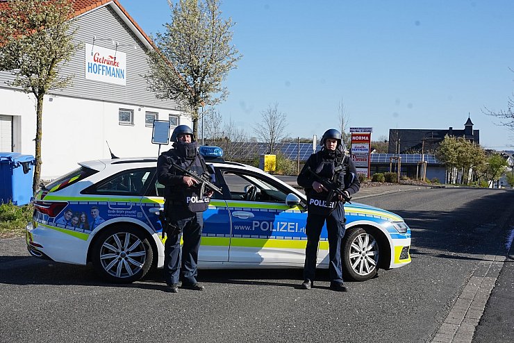 Polizisten am Ortseingang von Weitefeld. - © Thomas Frey/dpa