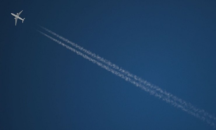 Ein Passagierflugzeug hinterlässt beim Flug CO2 und Kondensstreifen. (Archivbild) - © Arne Dedert/dpa