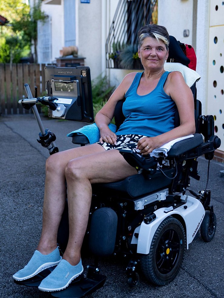 Die an ALS erkrankte Gabriele Engel sitzt im Rollstuhl vor ihrem Haus. - © Lennart Preiss/dpa