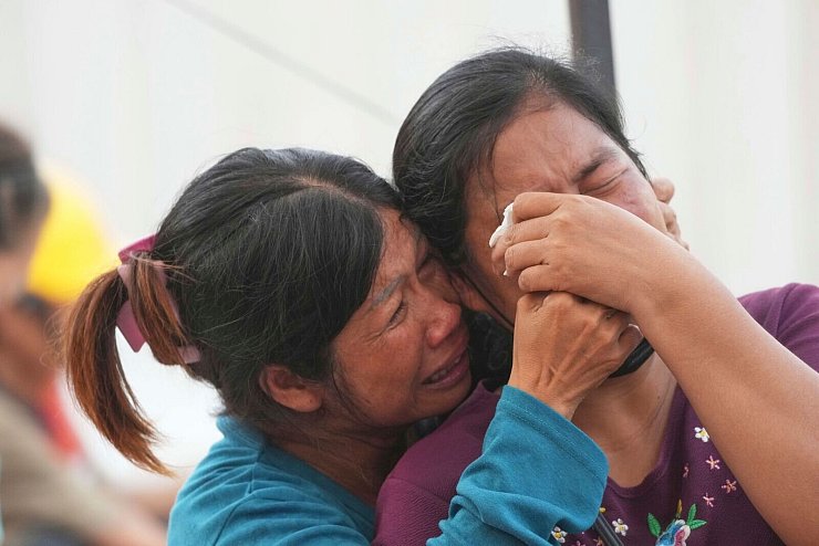 Verzweifelte Angehörige harren an der Unglücksstelle aus. Bei den meisten Bauarbeitern handelte es sich um Burmesen. - © Sakchai Lalit/AP/dpa