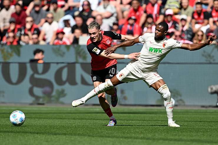 Florian Wirtz (l) leitet das 1:0 für Leverkusen ein. - © Federico Gambarini/dpa