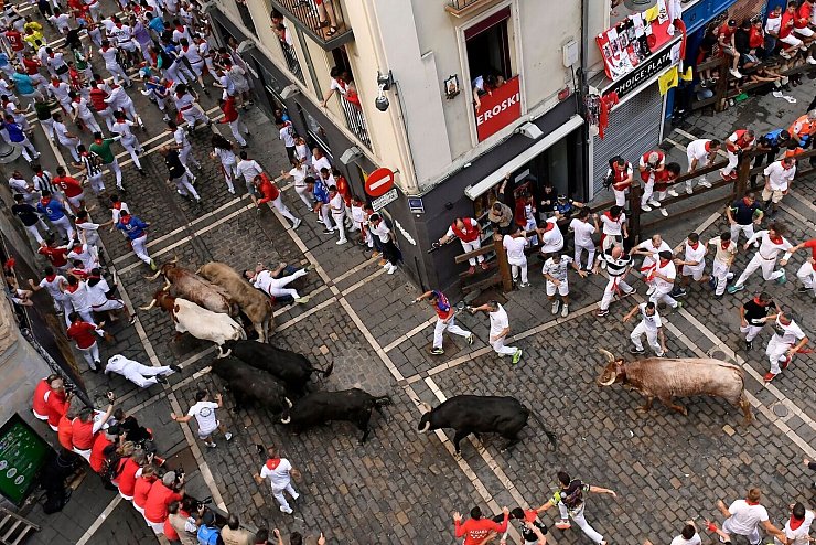 Besonders in Kurvern auf der mehr als 800 Meter langen Strecke kommt es immer wieder zu gefährlichen Szenen. Wer stürzt, soll flach liegen bleiben und die Hände schützend über den Kopf halten, bis die Meute vorbeigeprescht ist. - © Alvaro Barrientos/AP/dpa
