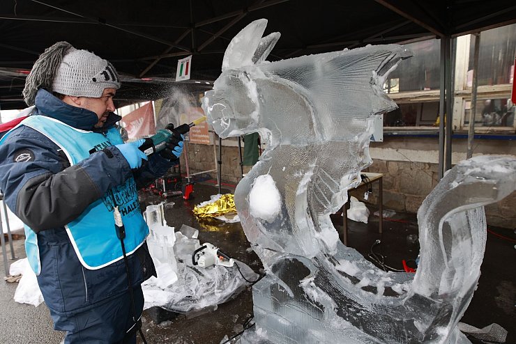Weltcup im Eisskulpturenschnitzen: Ein Teilnehmer des Eisskulpturen Weltcup bearbeitet einen Eisblock mit einem Werkzeug. - © Matthias Bein/dpa